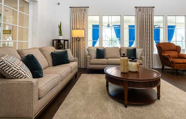 A living room with a beige couch, a round coffee table, and a chair.