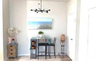 A room with a desk, chair, and a painting on the wall.