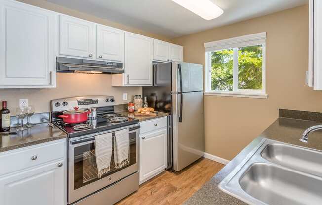 a kitchen with stainless steel appliances and white cabinets  at Springfield, Renton, 98055