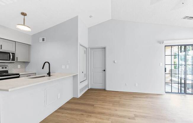 A kitchen with white cabinets and a black stove top oven.