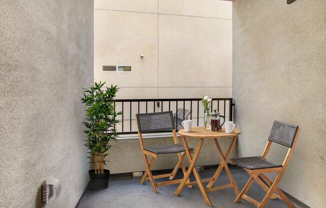 a small table and two chairs on a balcony