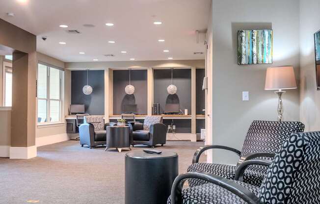 a lounge area with chairs and tables and a tv