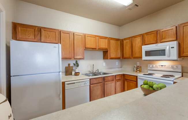 a kitchen with white appliances and wooden cabinets