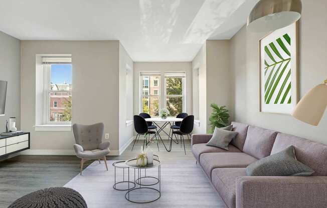 A living room with a grey couch, a white chair, a black chair, a coffee table, and a large painting on the wall.