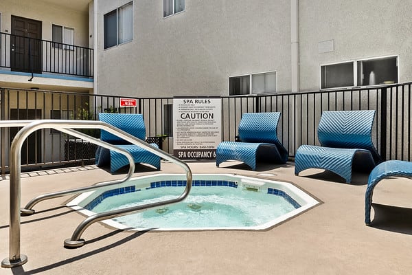 a jacuzzi pool with blue chairs and a black fence at NOHO GALLERY Apartments, North Hollywood , California