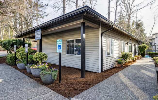 a small white building with a parking lot in front of it