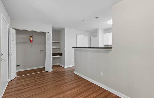A room with a white door and a white wall with a fire extinguisher on the shelf.