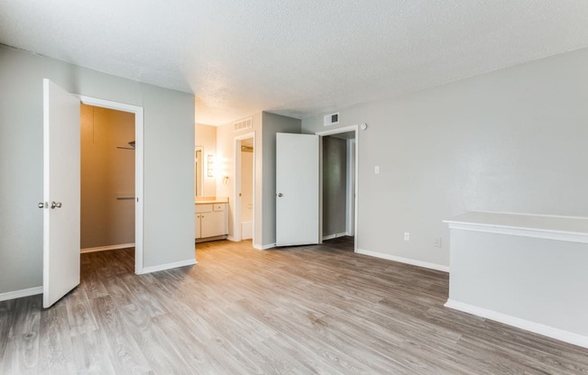 an empty living room with wood flooring and white walls