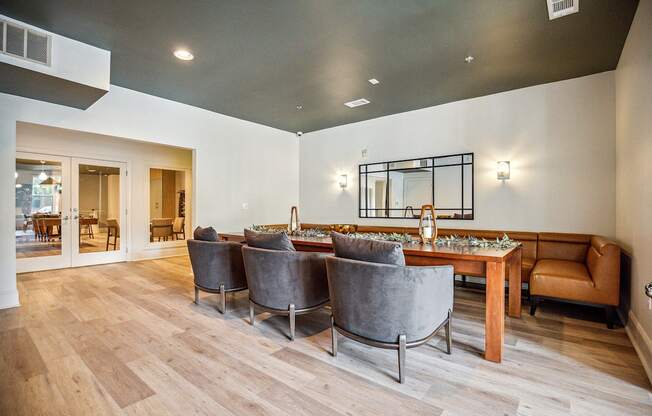 A modern dining room with a long table and grey chairs.