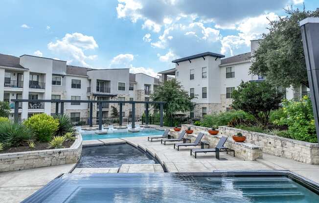 resort-style swimming pool with sun deck lounging areas at The Allure apartments