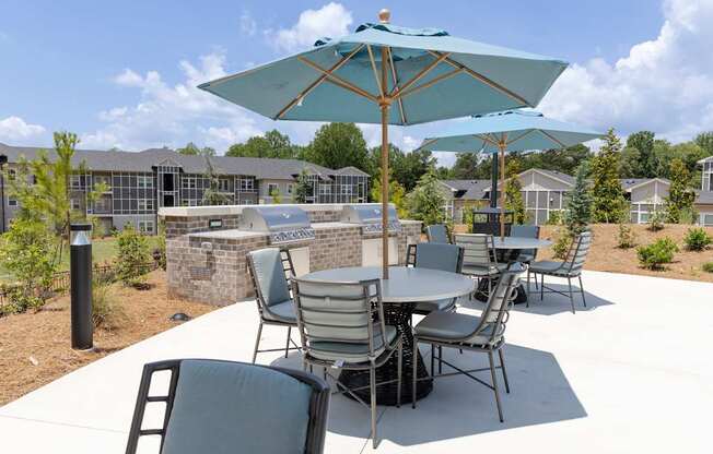 A patio with a table and chairs under an umbrella.