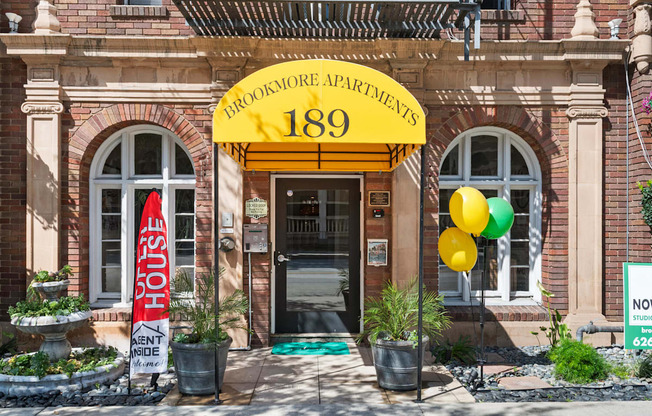 The front of Brookmore Apartments is shown with balloons and an awning.