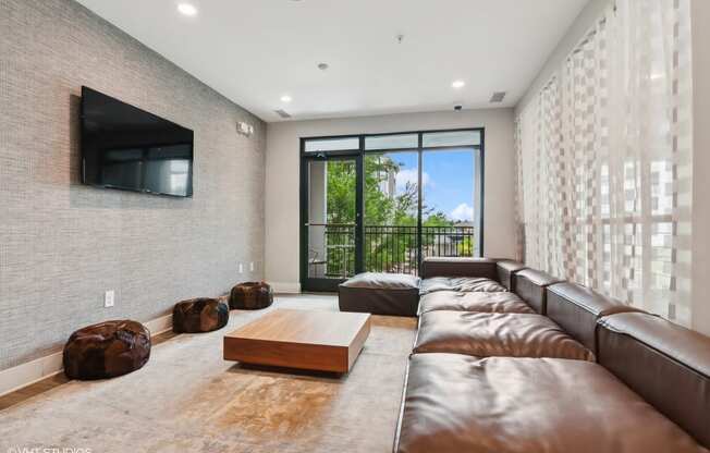 a living room with leather couches and a television on the wall