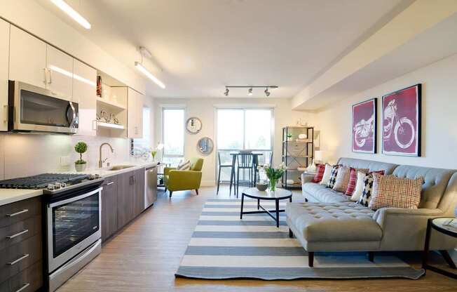 A modern kitchen with a large island and a living room with a couch.