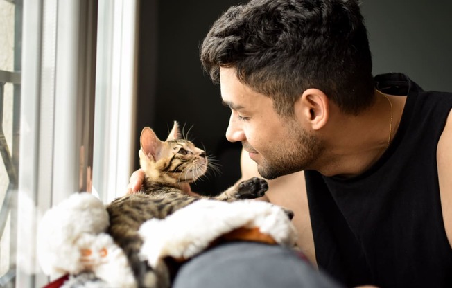 a man and his cat looking out the window