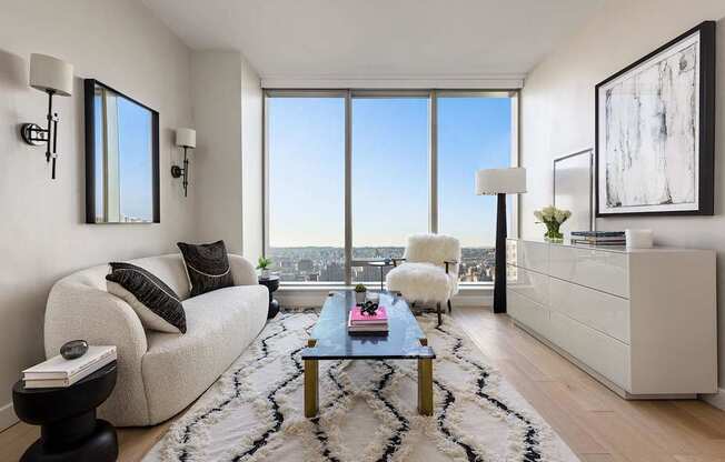 a living room with a view and a couch and a table at The Paxton, New york