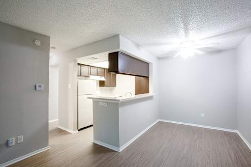A kitchen area with a white counter and a refrigerator.