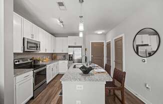 A modern kitchen with white cabinets and a granite countertop.