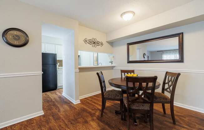 a dining room with a table and chairs and a mirror