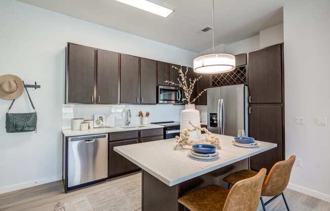 a kitchen with a large island and stainless steel appliances