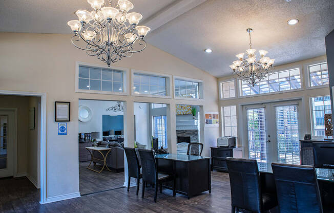 a dining room and living room with large windows and chandeliers