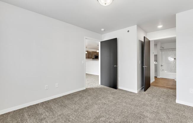 a bedroom with grey carpet and white walls