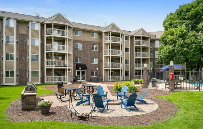 an outdoor patio with tables and chairs in front of an apartment building