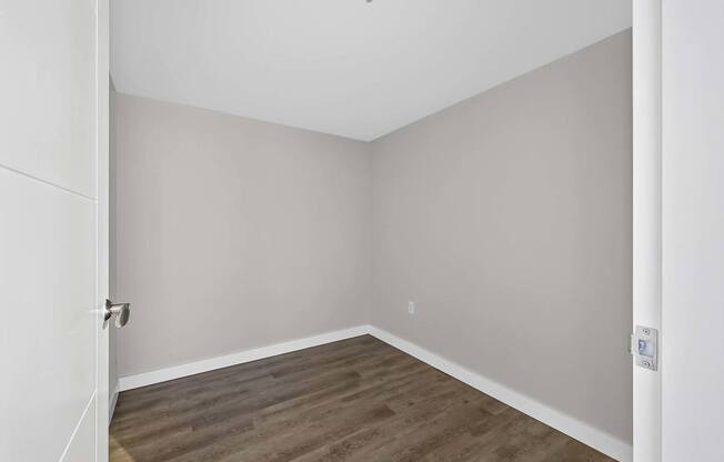 A room with a wooden floor and white walls.
