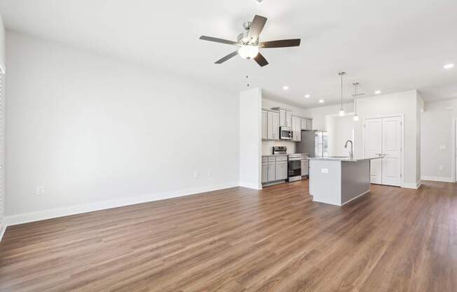 A room with a ceiling fan and wooden flooring.
