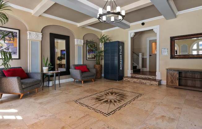 The leasing office at Brookmore Apartments Pasadena with a rug in the middle and a chandelier hanging from the ceiling.