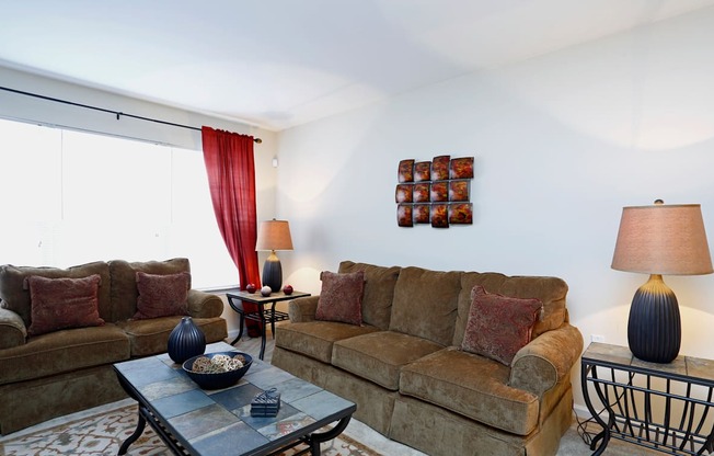 A living room with a couch, a coffee table, and a side table with a lamp.