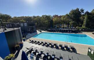 an aerial view of a swimming pool and deck with chairs at The Boulevard, Roeland Park, KS