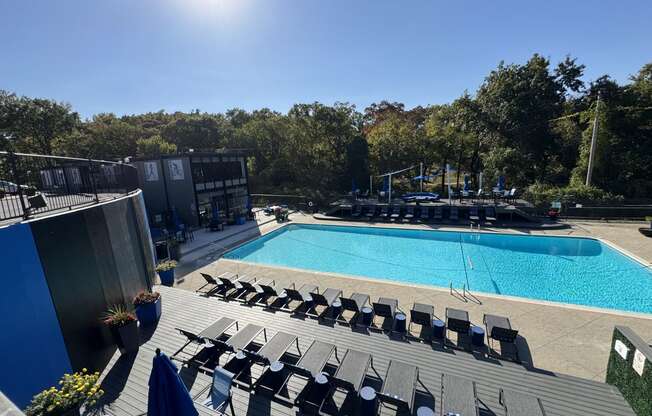 an aerial view of a swimming pool and deck with chairs at The Boulevard, Roeland Park, KS