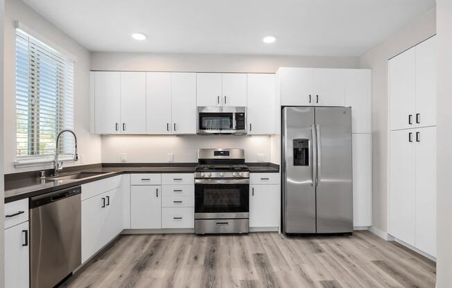 a kitchen with white cabinets and stainless steel appliances