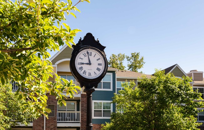 a clock on a pole in front of a building