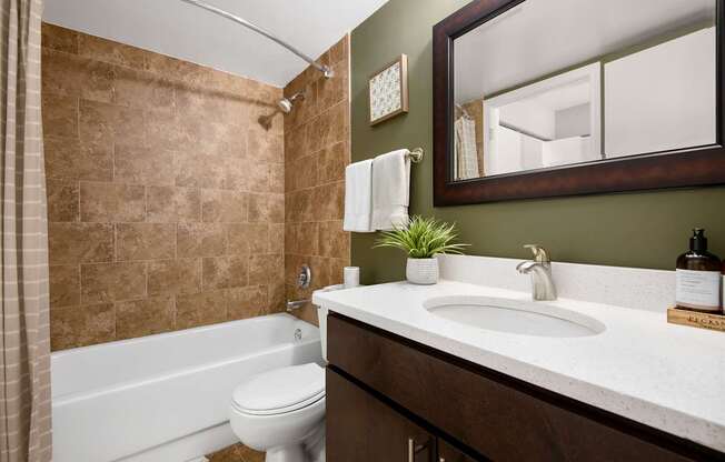 A bathroom with a white tub, sink, and toilet.
