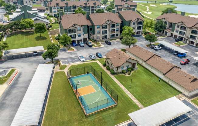 an aerial view of a basketball court in front of apartments