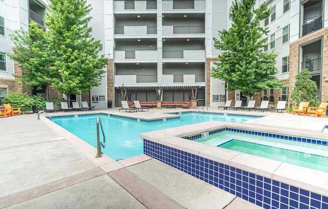 A large swimming pool surrounded by apartment buildings.