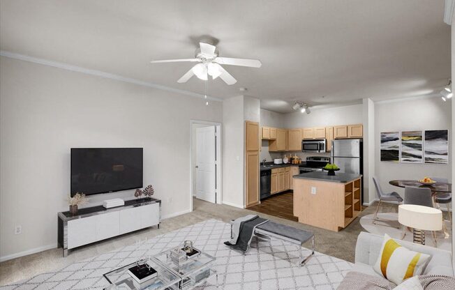 a living room with a ceiling fan and a kitchen