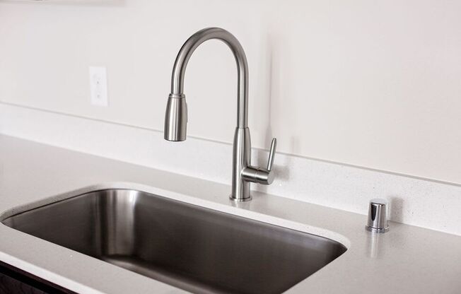 a kitchen sink with a chrome faucet