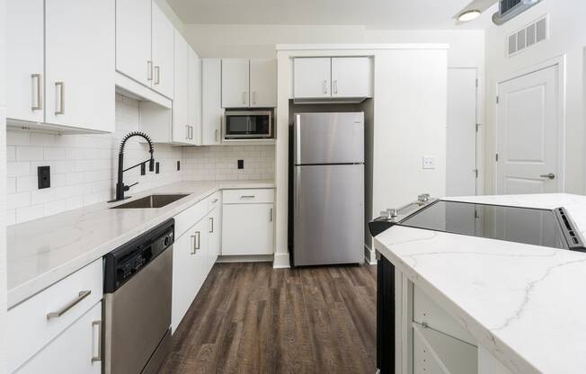 a kitchen with white cabinets and a stainless steel refrigerator