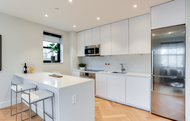 Open custom kitchen with quartz countertops, hardwood floors and Bosch appliances