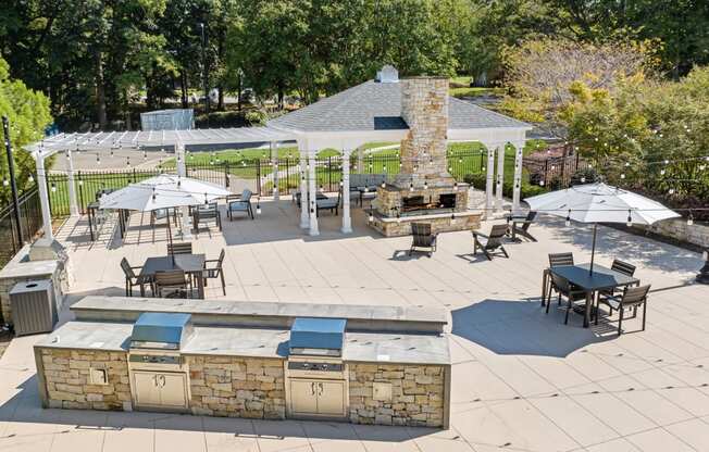 a patio with a grill and tables with umbrellas at View at Lake Lynn, Raleigh, 27613