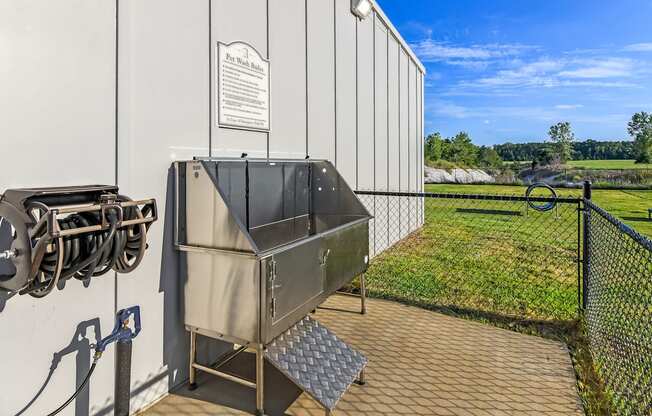an outdoor patio with a grill and a building with a field of grass at Avalon Apartments Starkville, MS