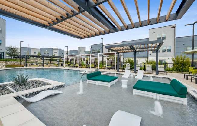 a resort style pool with lounge chairs and a pergola