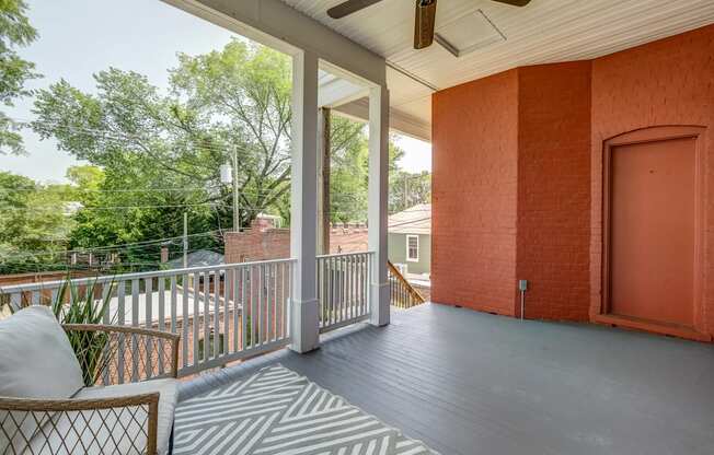 A balcony with a chair and a ceiling fan.