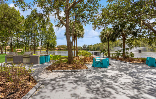 Pathway with tables and chairs on it with the lake  in the background