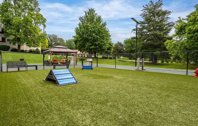 A playground with a slide, a swing set, and a fire hydrant.