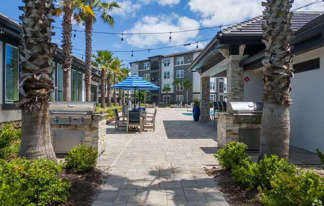 A sunny day at a resort with palm trees and a walkway.