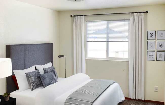 a bedroom with a bed and a window with red curtains at Shiloh Glen, Montana